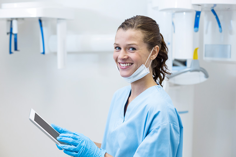 smiling-dental-assistant-using-digital-tablet-LGQ7DA2-1