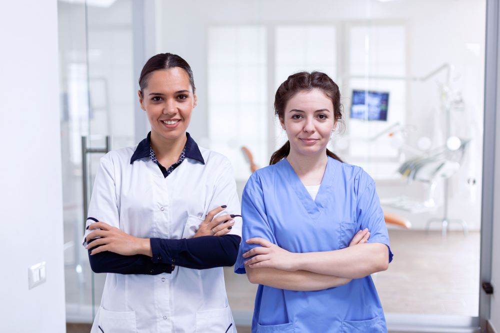 portrait-of-smiling-dentist-and-nurse-smiling-7M2C4CQ