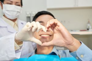 patient-and-dentist-showing-heart-gesture-with-han-2G5ZQAF